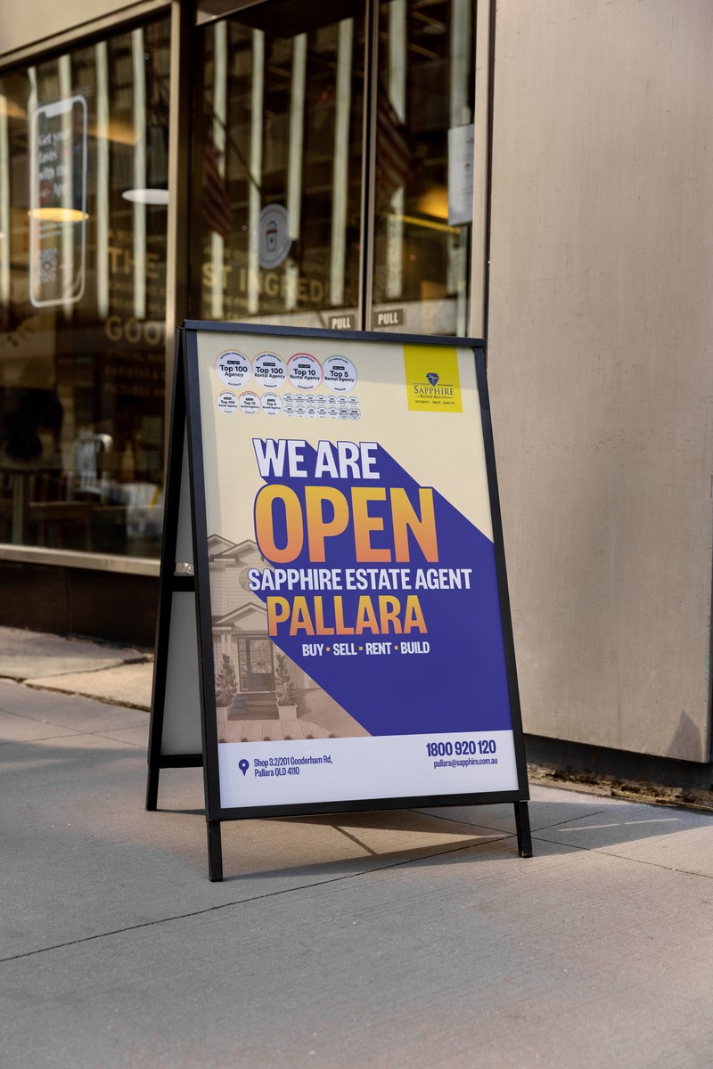 An A-frame sign reading We Are Open outside a glass shopfront